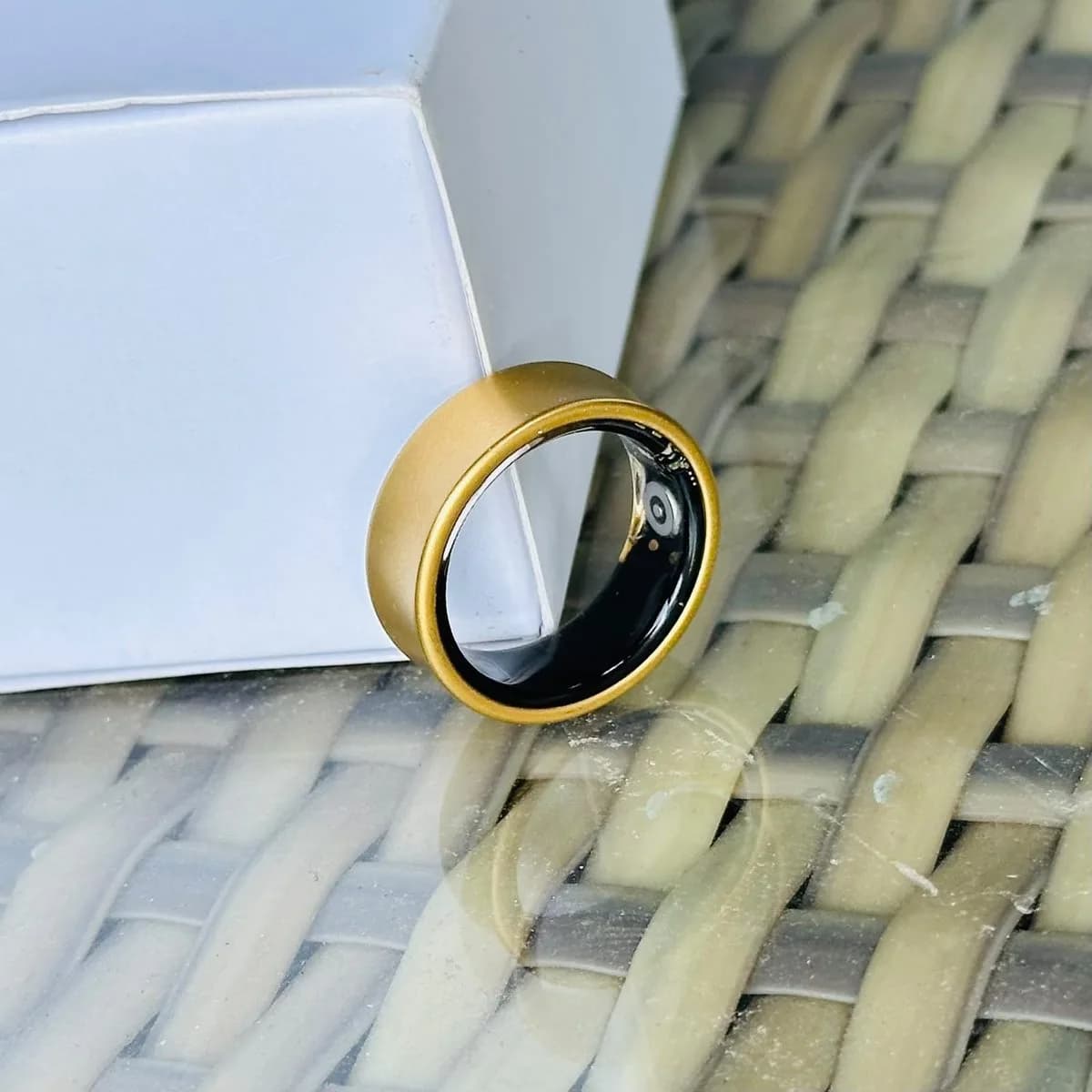 i do smart ring, gold finish, resting on its box